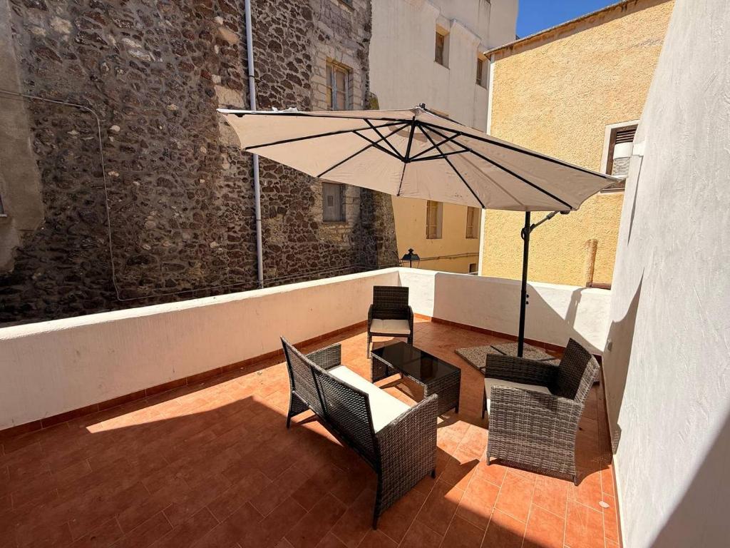 a patio with a table and chairs and an umbrella at Guest House - Appusentu in Castelsardo
