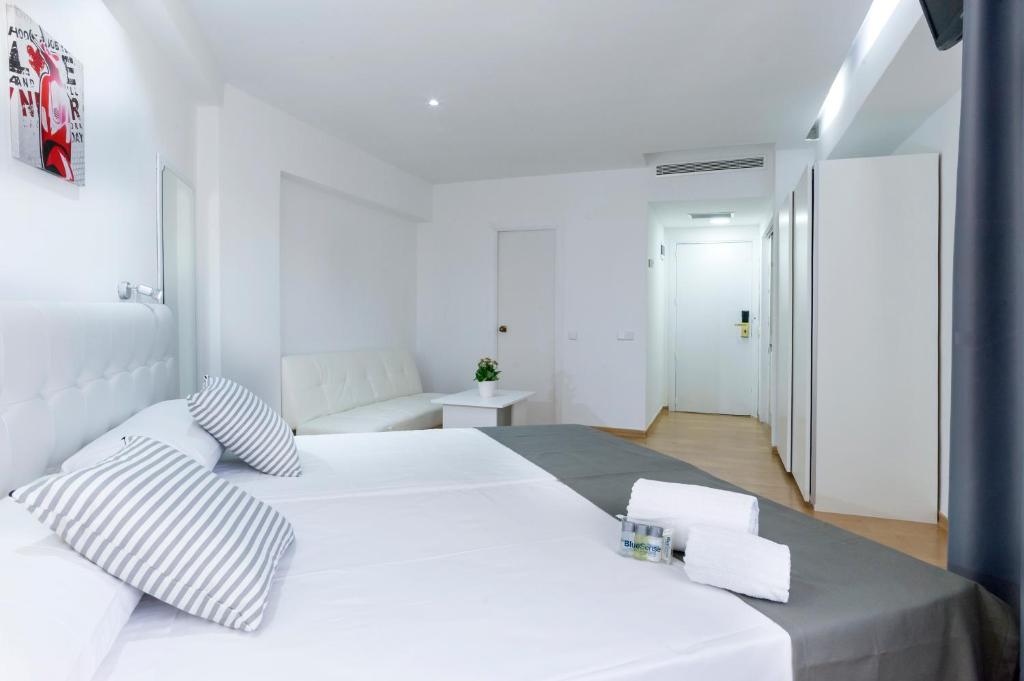 een witte slaapkamer met een groot wit bed met kussens bij Boutique Urban Madrid Génova in Madrid