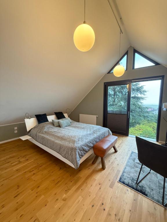 a bedroom with a bed and a large window at Huus Bellevue in Gleisweiler