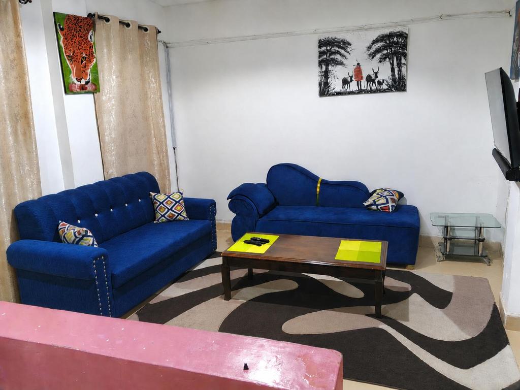 a living room with two blue couches and a coffee table at Daja Airbnbs in Thika