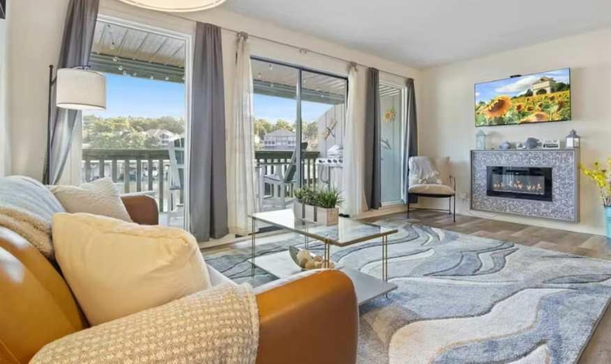a living room with a couch and a fireplace at The Luxe Lakefront in Lake Ozark