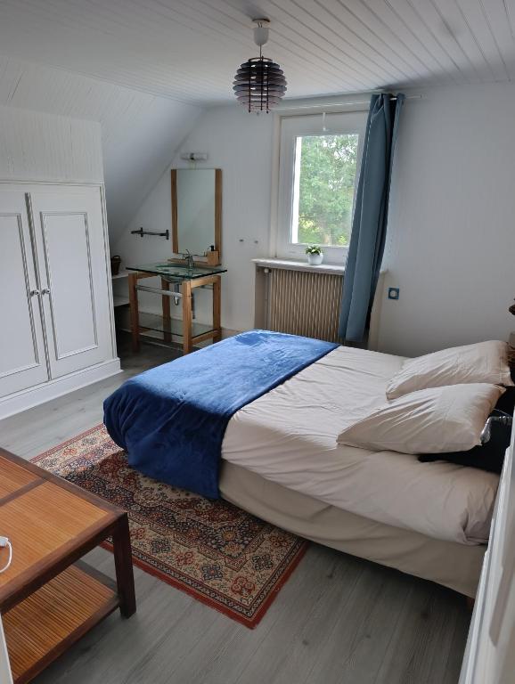 a bedroom with a large bed and a table at Trégouët 8 - Chambre 2 in Saint-Nazaire