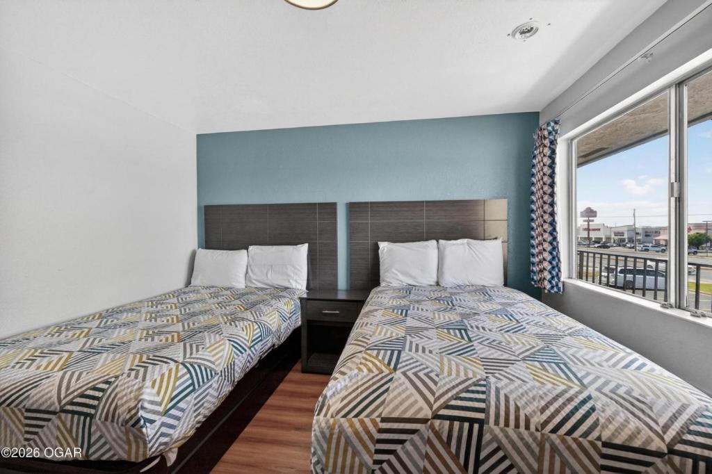 a hotel room with two beds and a window at Super 7 inn in Joplin