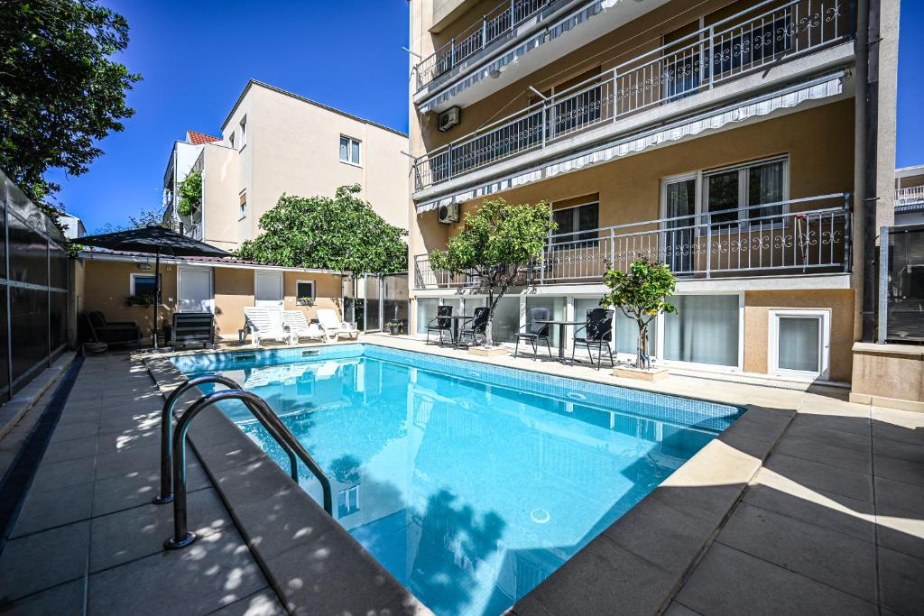 a swimming pool in front of a building at Mikuljan Apartments with Pool-5 min to Beach & Private Parking Included in Stobreč