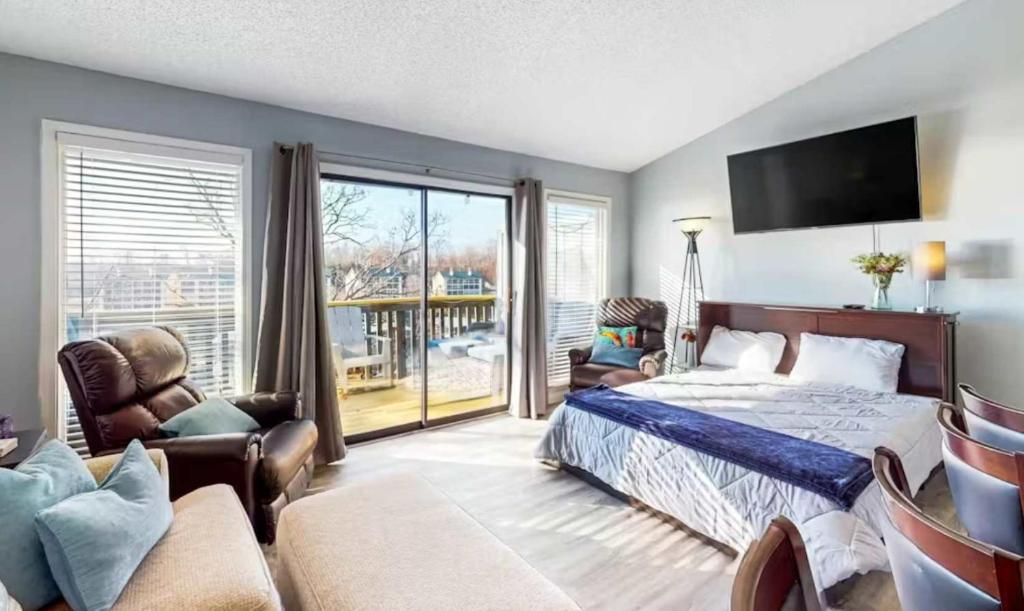a bedroom with a bed and a tv and a couch at Southwood Serenity in Lake Ozark