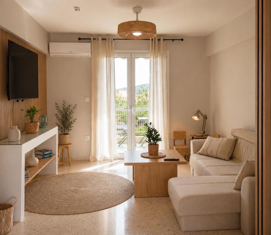 a living room with a couch and a tv at VERADO by A&D Properties in Porto Rafti