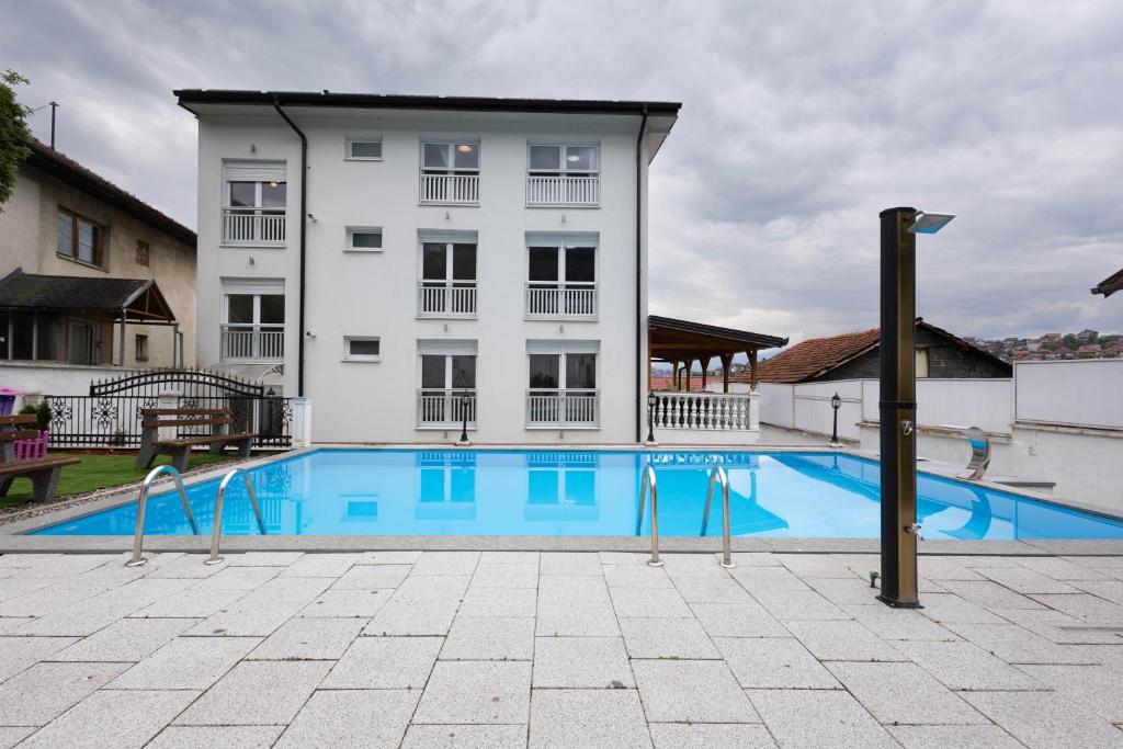 a building with a swimming pool in front of a building at Lumina Residence in Sarajevo