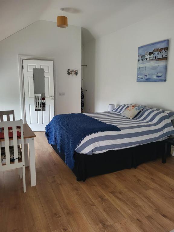 a bedroom with a large bed and a wooden floor at McGrath's Bar & Accommodation Causeway in Causeway