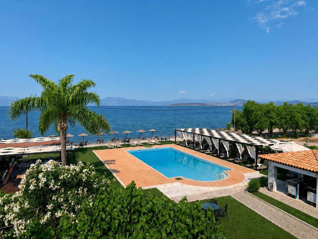 a swimming pool with chairs and a view of the ocean at Blue escape in Nafplio