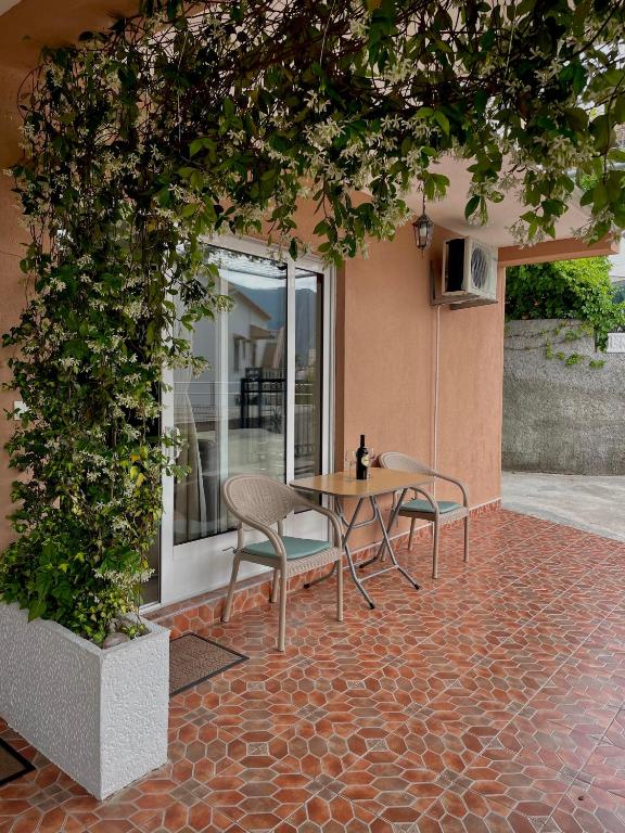 a patio with a table and chairs on a brick floor at Apartments Marash in Kotor