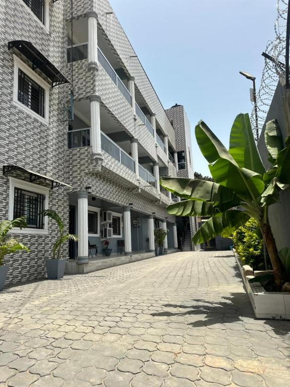a building with a cobblestone street in front of it at Stepping Stone Apartments in Bijilo
