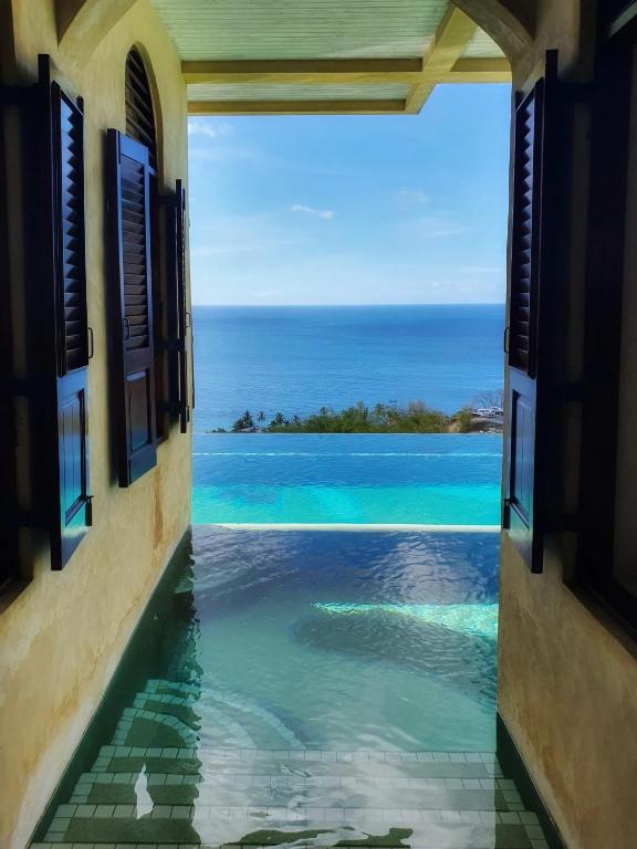 an open window with a view of the ocean at Villa Azulejo in Black Rock