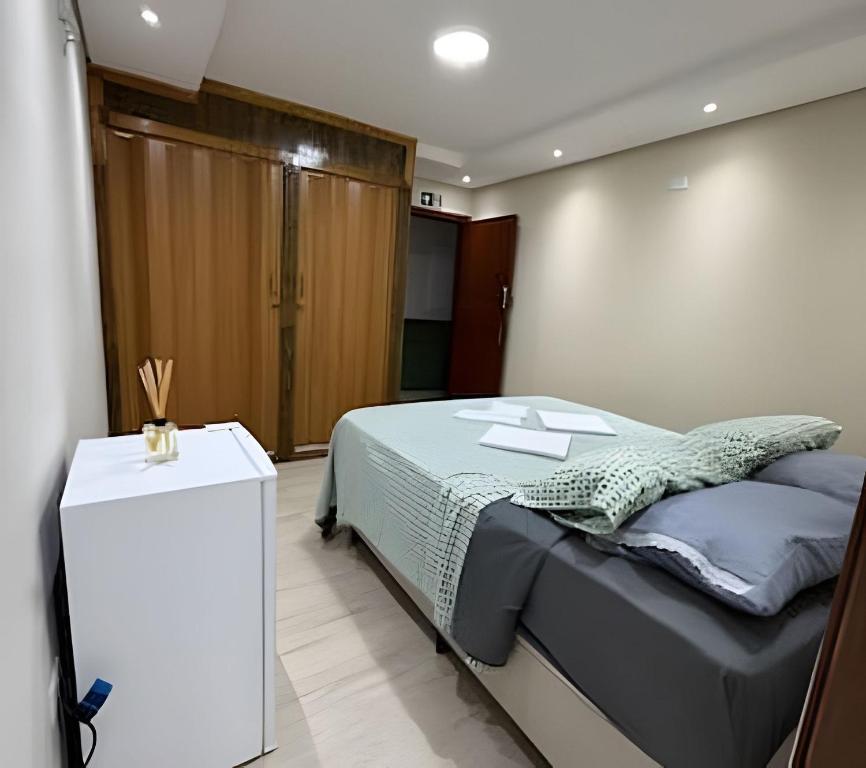 a bedroom with a bed and a white table at Madonna Prime Studio Hotel Extrema MG + breakfast in Extrema
