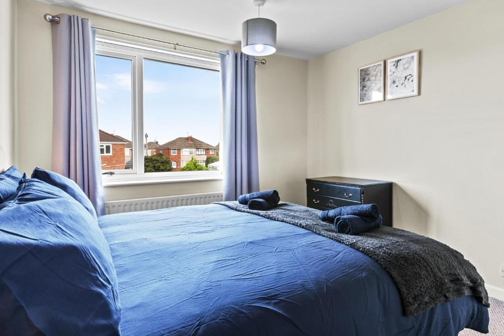 a bedroom with a blue bed and a window at Great Sutton House Perfect for Contractors in Sutton