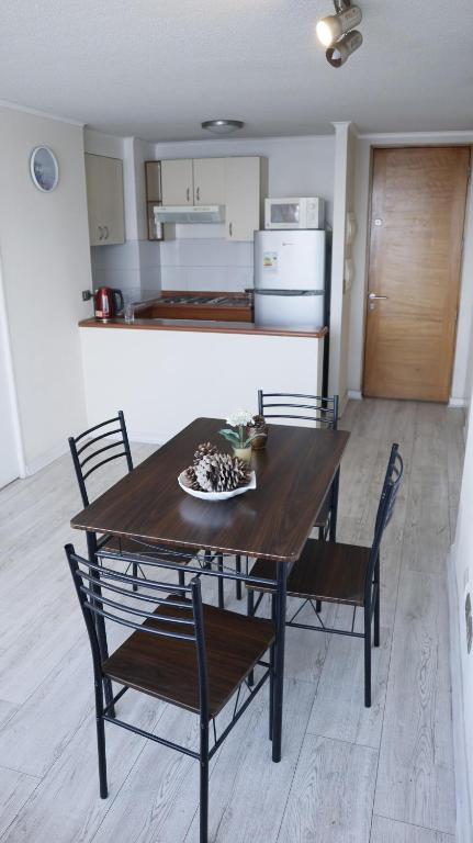 a dining room table with chairs and a kitchen at Departamento Centro Concepción in Concepción