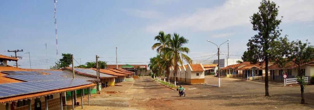 a person riding a bike in a village with solar panels at Pousada Os Galeguinhos in Santa Cruz do Rio Pardo