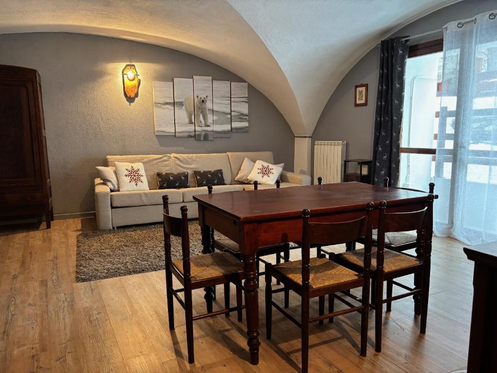 a living room with a table and chairs and a couch at Appartamento Grangia Rigat, Bousson, Cesana Torinese in Bousson