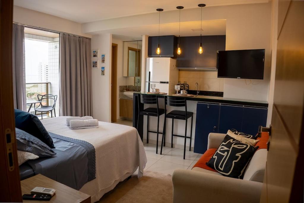 a bedroom with a bed and a kitchen with a counter at Studio premium aconchegante vista mar in São Luís