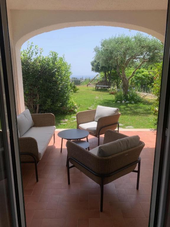 a patio with chairs and a table and a view of a field at Villa 4 Rose in Sant'Angelo D'Ischia