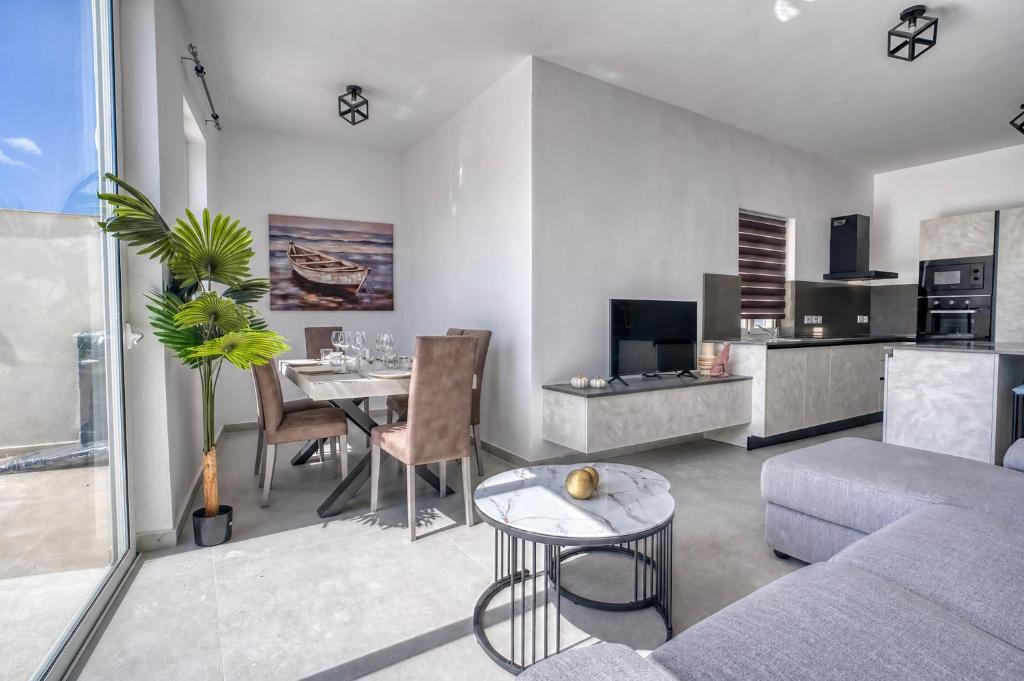 a living room with a couch and a table at St Julian s Luxury Laura Apartments in Is-Swieqi