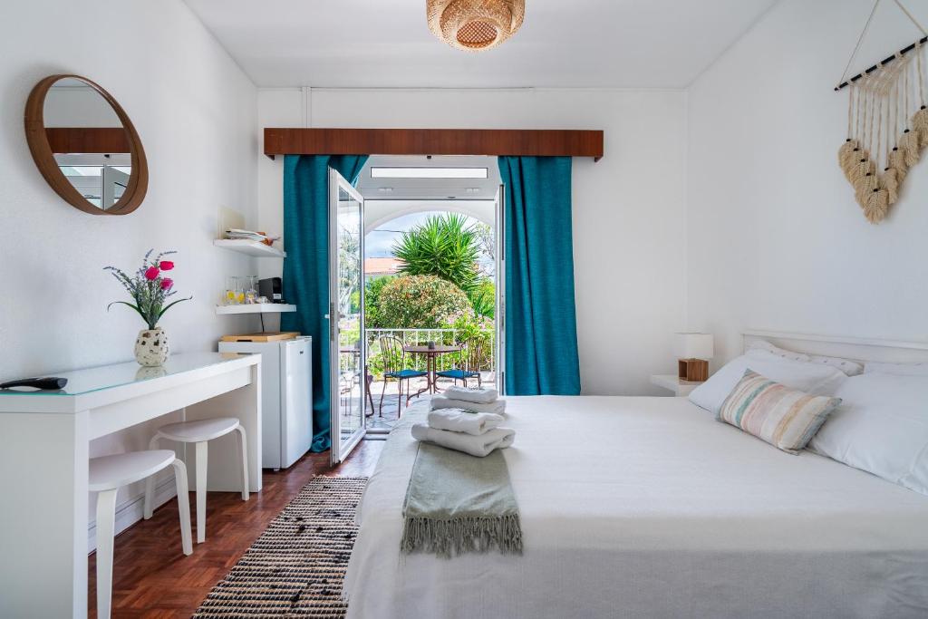 a bedroom with a bed and a desk and a window at Vivenda Aromas do Algarve in Monte Raposo