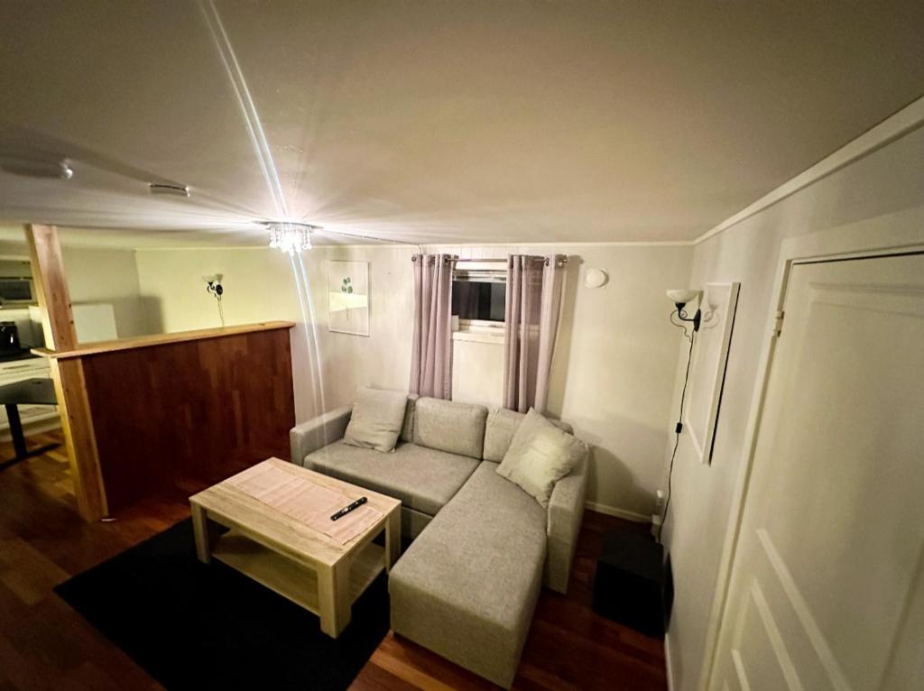 a small living room with a couch and a table at Sjøveien 43 in Vestvågøya