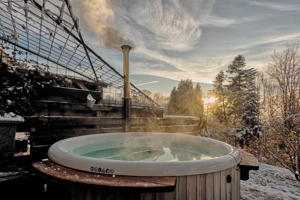 a jacuzzi tub in the snow with a stairysicalysicalysicalysical at La Loge du Pic Noir in Dabo