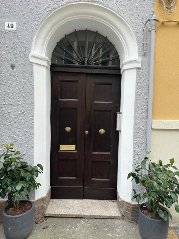 a large wooden door with an arch in a building at Suite Cerchio 3 - City Center in Ravenna