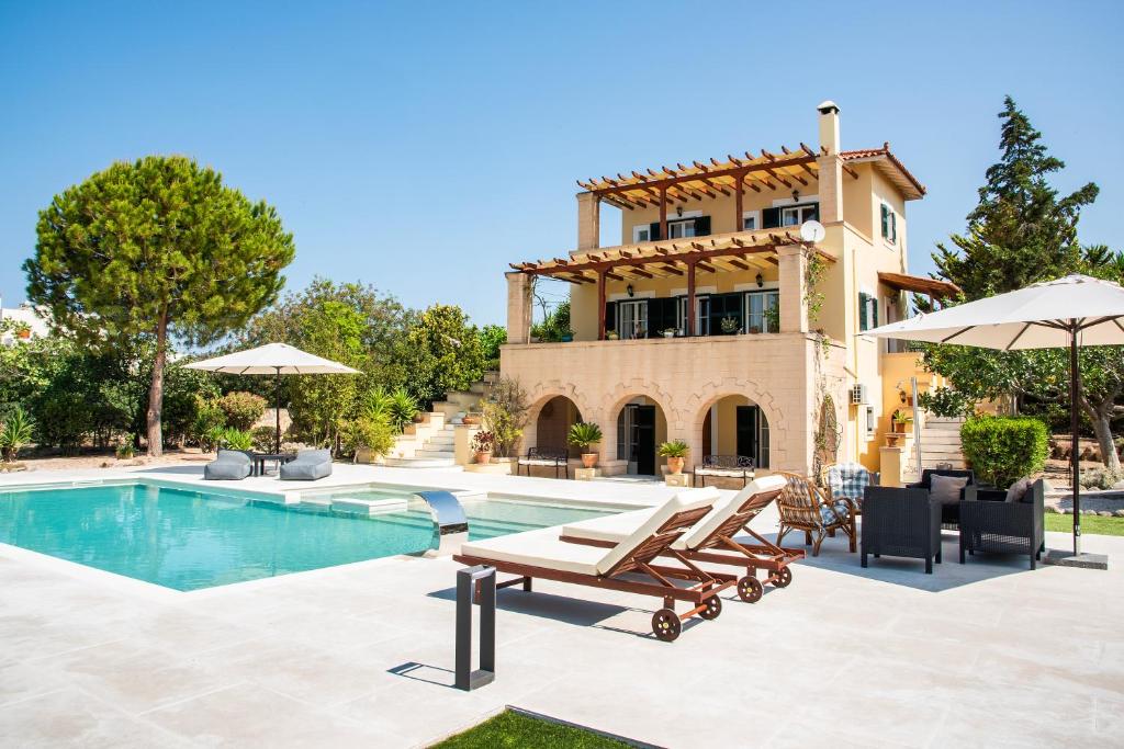 a villa with a swimming pool and a house at Villa Ersilia in Egina