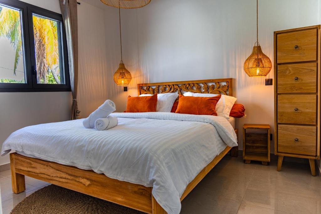 a bedroom with a bed with a teddy bear on it at Les Clos de L Albatros in Saint-Paul