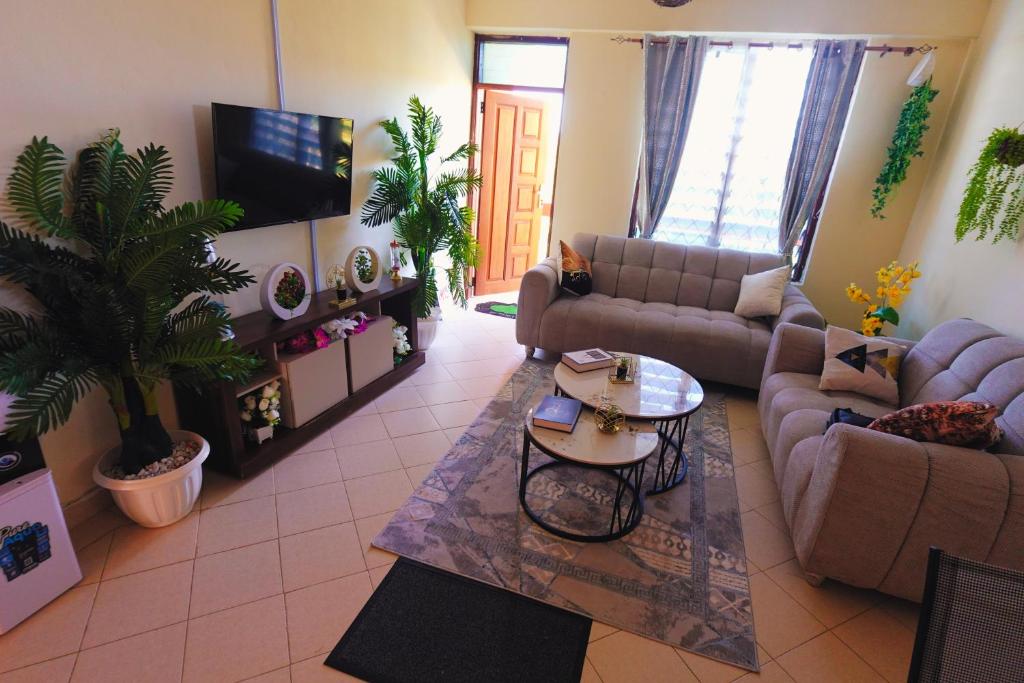 a large living room with couches and a tv at The Nest Apartment Darad in Ukunda Airport
