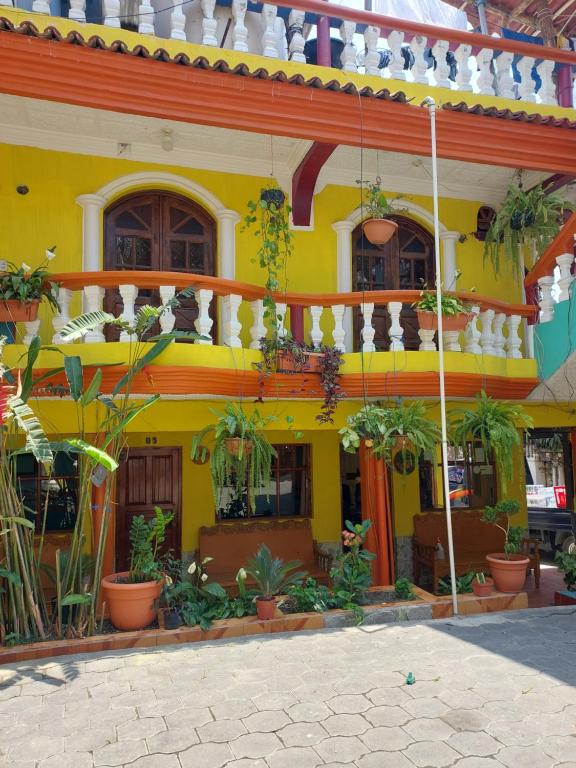 a yellow building with plants in front of it at Hotel Casa Ramos in Panajachel
