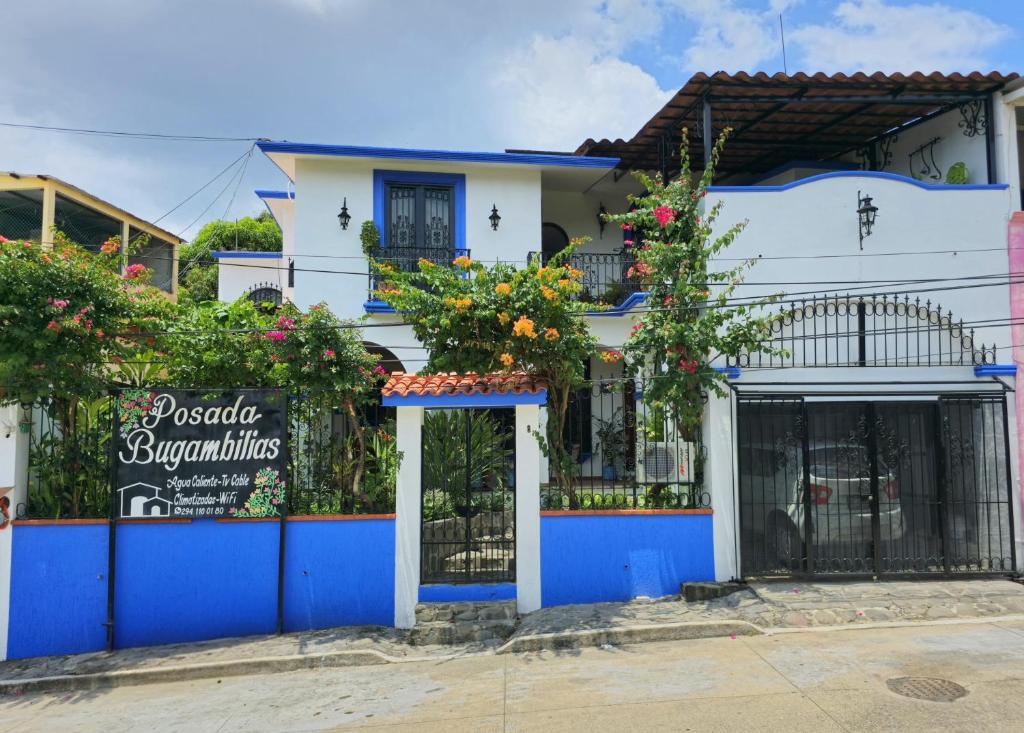 a blue and white house with a sign in front of it at Posada Bugambilias in Catemaco