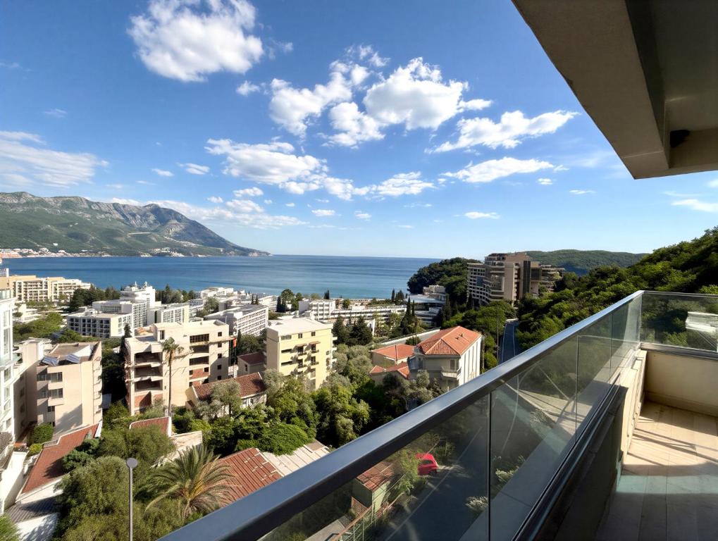 a balcony with a view of a city and the ocean at Boreti Apartment in Budva