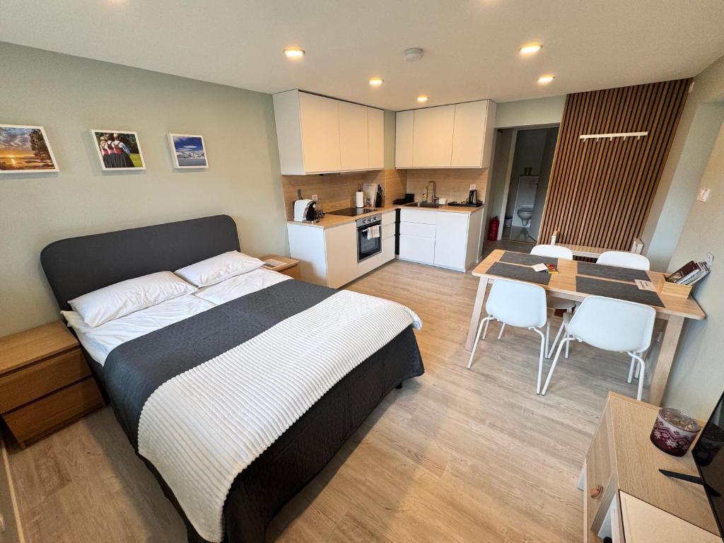 a bedroom with a bed and a kitchen with a table at Fjord studio in Sunde