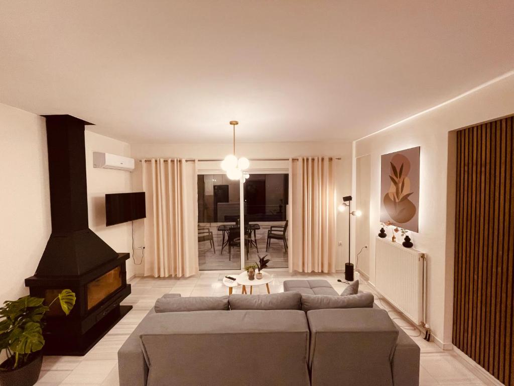 a living room with a couch and a fireplace at Elenas sweet home - Penthouse with Large Balcony in Pyrgos