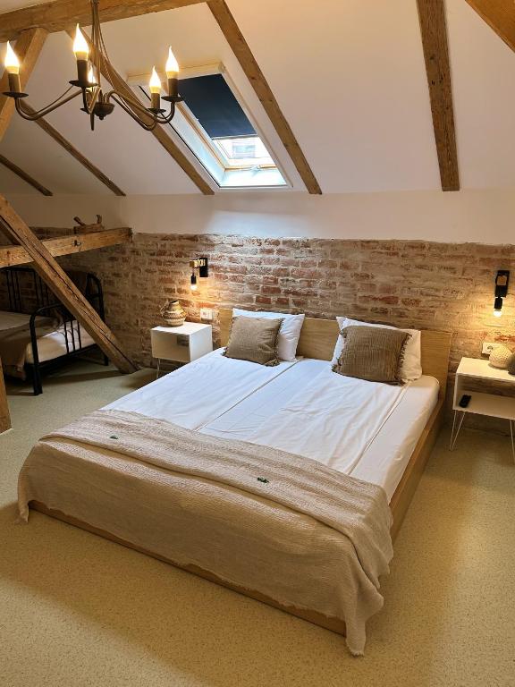 a bedroom with a large bed with a brick wall at TimHouse in Timişoara