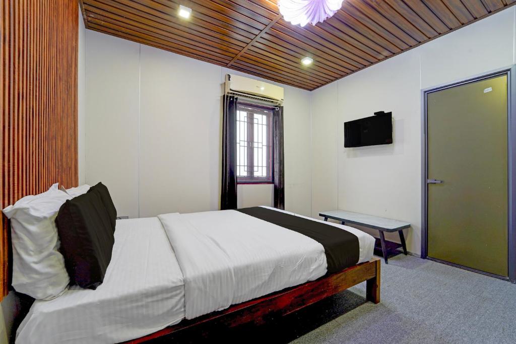 a bedroom with a bed and a table and a television at Super Hotel O AM Grandd in Kāraikkudi