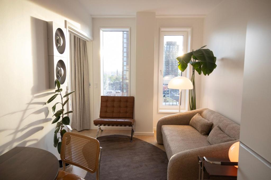 a living room with a couch and a chair at Designer apartment with city view in Copenhagen