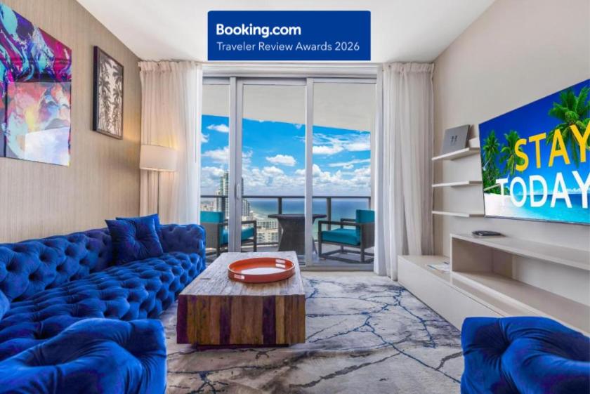 a living room with a blue couch and a tv at Heaven Resort - 2BDR BEACH HOME WITH OCEAN VIEW HOLLYWOOD! in Hollywood