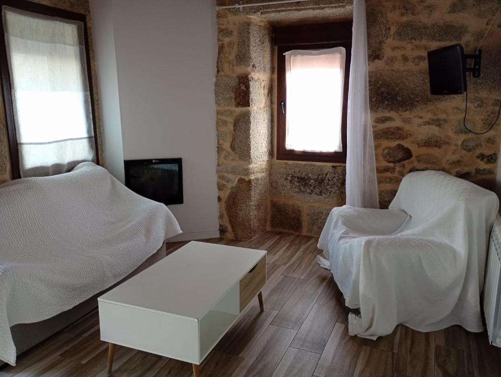 a bedroom with two beds and a table and a chair at Casa rústica busto in Armentera