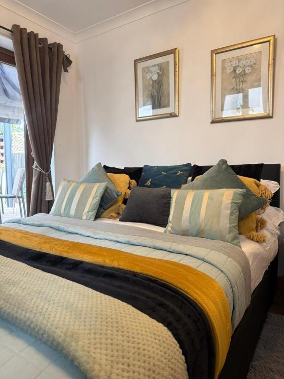 a bedroom with a large bed with colorful pillows at Studio A - Newly renovated 2 bed studio in Nottingham