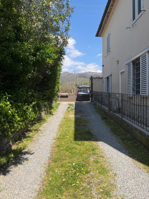 a gravel road next to a white house at Casetta di pisolo in Pistoia
