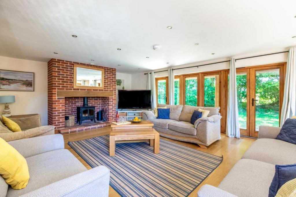a living room with couches and a fireplace at 4 Bed in Fakenham oc-1261 in Thursford