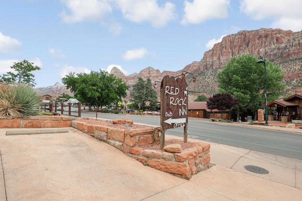 a sign on the side of a street with mountains in the background at Red Rock Inn Cottages in Springdale