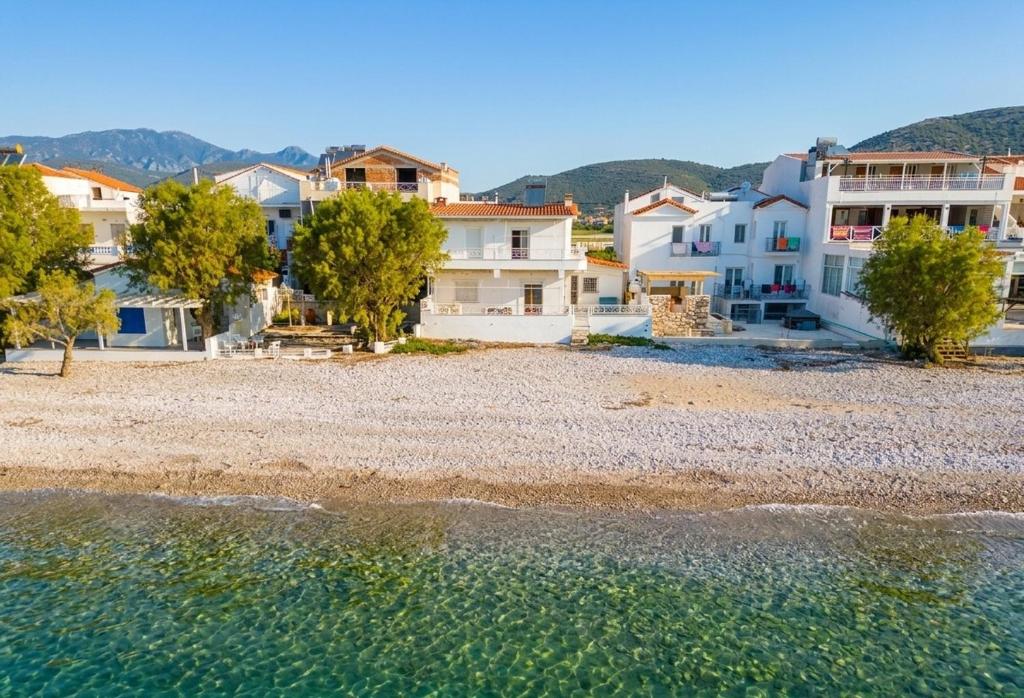 a group of houses on a beach next to the water at Potokaki Coastal Haven in Potokáki