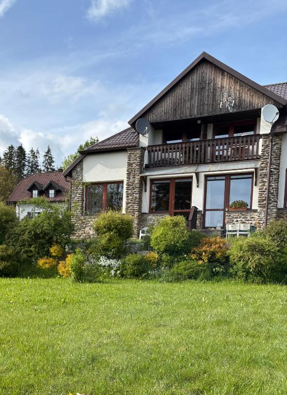 a large house with a large yard in front of it at Penzion u Zdichynců in Kubova Huť
