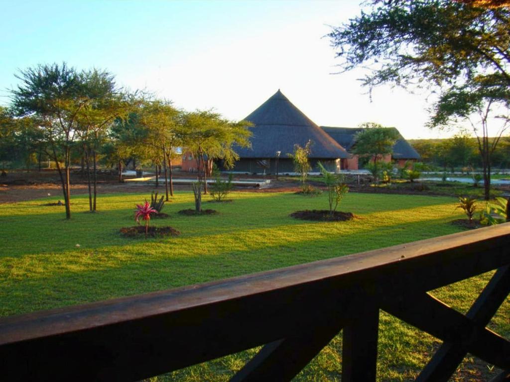 a view of a park with a building at Chobe Lesoma Chalets Hotel in Lesoma