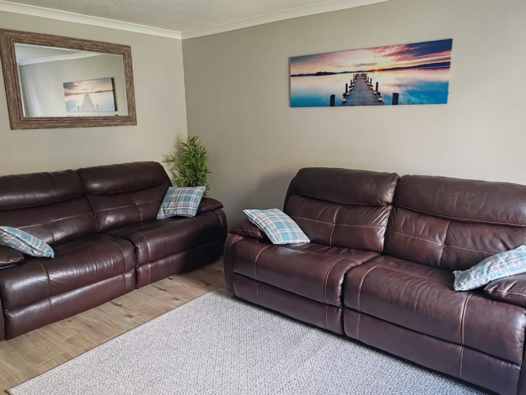 a living room with a brown leather couch at Modern living in Hull in Hull