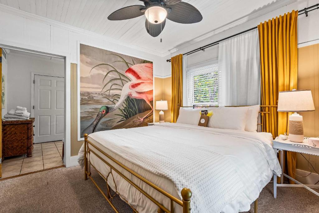 a bedroom with a large bed with a painting on the wall at Old Carrabelle Hotel Magnolia Suite in Carrabelle